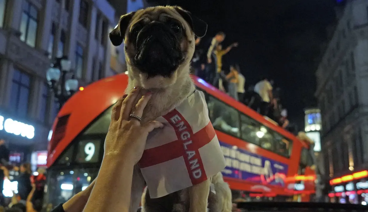 Pendukung Inggris merayakan kemenangan setelah pertandingan UEFA EURO 2020 antara Inggris dan Denmark, di London pusat (8/7/2021). Ini menjadi sejarah baru untuk The Three Lions. (AFP Photo/Niklas Halle’n)