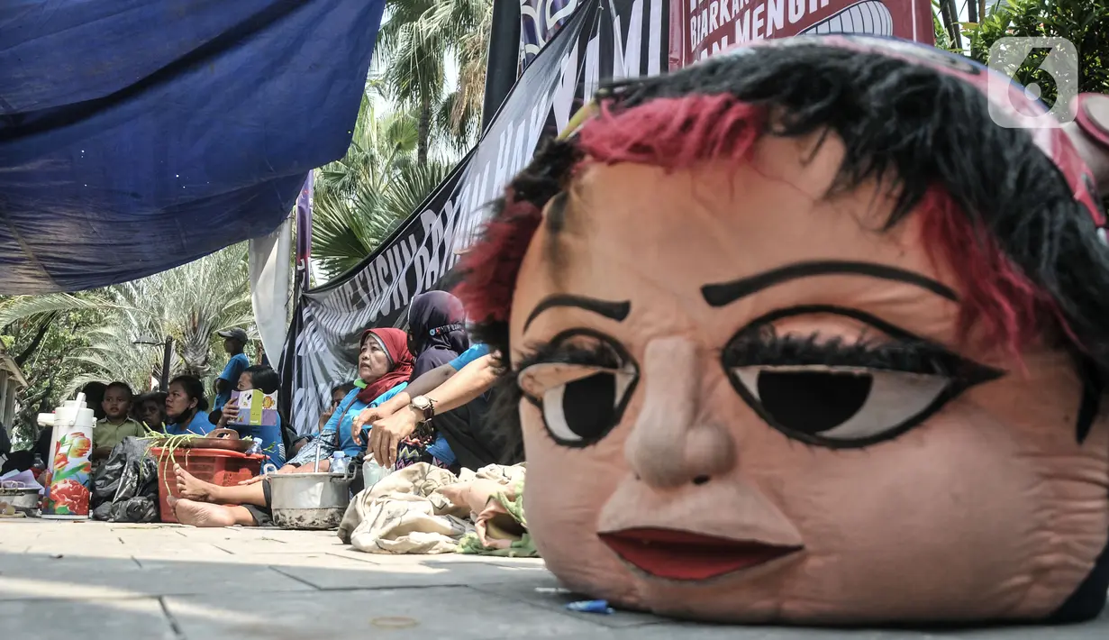 Warga gusuran Kampung Bayam saat menggelar aksi di depan Balai Kota DKI Jakarta, Kamis (1/12/2022). Dengan membawa terpal dan perabotan rumah tangga, puluhan korban gusuran Kampung Bayam mendatangi Balai Kota untuk menuntut PT Jakarta Propertindo (JakPro) segera menyerahkan kunci hunian Kampung Susun Bayam (KSB) serta memberikan harga sewa yang murah. (merdeka.com/Iqbal S Nugroho)
