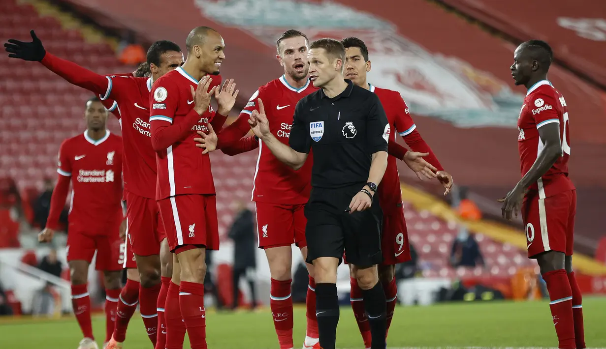 Para pemain Liverpool memprotes wasit Craig Pawson yang menganulir keputusan penalti usai memeriksa VAR dalam laga lanjutan Liga Inggris 2020/21 pekan ke-11 melawan Wolverhampton di Anfield Stadium, Minggu (6/12/2020). Liverpool menang 4-0 atas Wolverhampton. (Pool via AFP/Clive Brunskill)