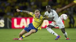 Pemain Real Madrid, Ferland Mendy, berebut bola dengan pemain Las Palmas, Oliver McBurnie, pada laga pekan ketiga La Liga 2024/2025 di Stadion Gran Canaria, Jumat (30/8/2024).  (AP Photo/Gabriel Jimenez)