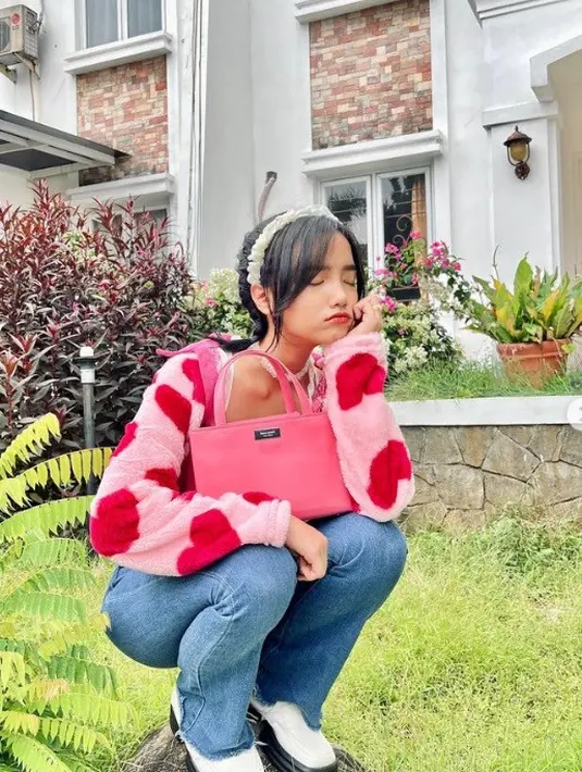 Fuji tampil serba pink juga tampak menenteng tas Kate Spade. Ia memadukan penampilan gemasnya mengenakan sweater bermotif dengan Sam Icon Mini Tote berwarna Feather Pink yang senada. Foto: Document/Kate Spade New York.