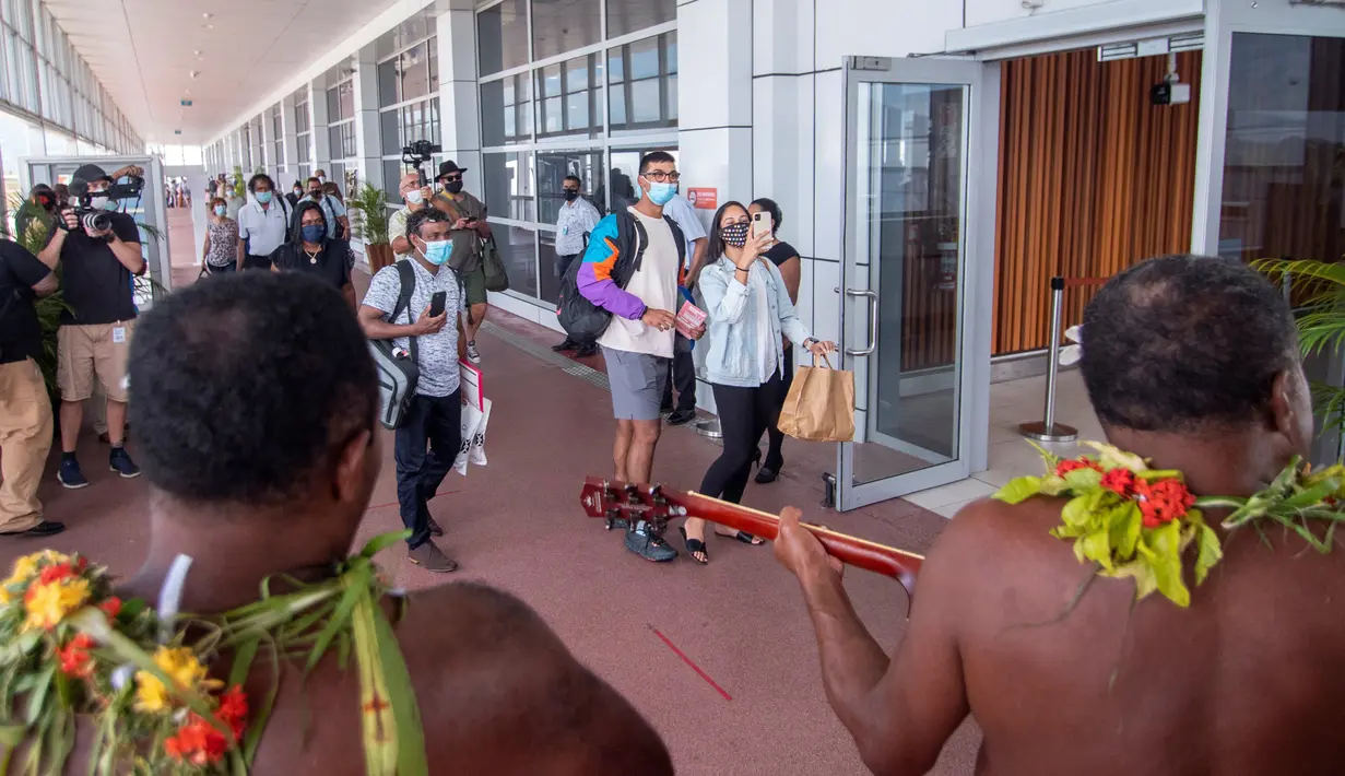 Penari tradisional dengan rok rumput menyambut wisatawan di Nadi, Fiji, Rabu (1/12/2021). Fiji membuka perbatasannya untuk pelancong internasional pertama kalinya sejak pandemi Covid-19 melanda dunia dan menghancurkan ekonominya yang bergantung pada pariwisata. (Handout/TOURISM FIJI/AFP)