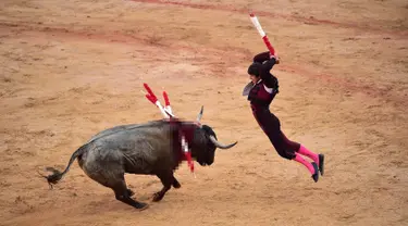 Matador Spanyol Joao Ferreira melompat untuk menusuk banteng saat bertarung dalam Festival San Fermin, Pamplona, Spanyol, Selasa (9/7/2019). (AP Photo/Alvaro Barrientos)