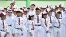 Seorang murid menguap diantara rekannya di sela upacara bendera di SDN Jatinegara Kaum 15 Pagi, Jakarta, Senin (15/7/2019). Sebanyak 32 anak menjadi murid baru SDN tersebut pada hari pertama masuk sekolah tahun ajaran 2019/2020. (merdeka.com/Iqbal S Nugroho)