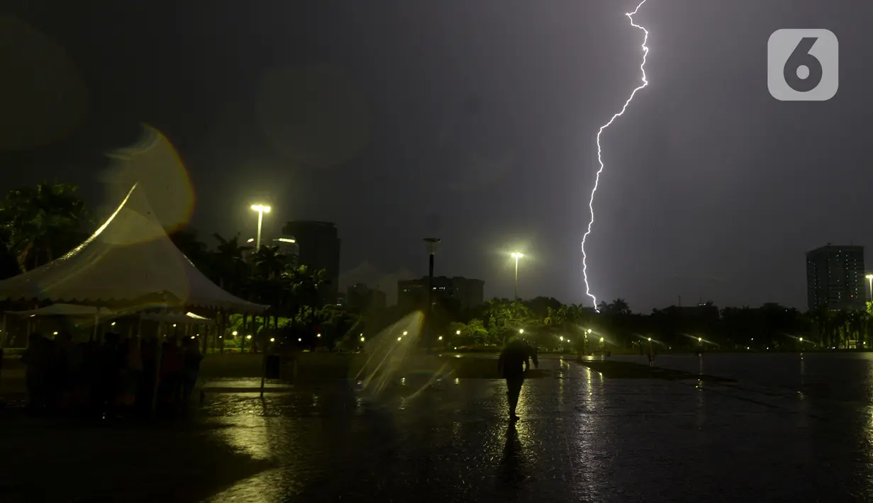 Kilatan petir menyambar di kawasan Monas, saat hujan yang disertai angin mengguyur Jakarta, Sabtu (21/12/2019),Malam. BMKG mengingatkan agar waspada terhadap potensi hujan deras yang disertai petir diprediksi akan terjadi dalam beberapa hari kedepan. (merdeka.com/Imam Buhori)