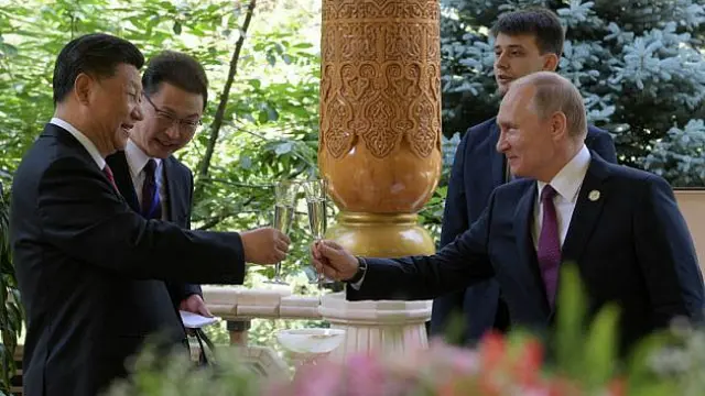 Presiden Rusia Vladimir Putin dan Presiden China Xi Jinping bersulang untuk merayakan ultah Xi ke-66 (Sputnik / AFP PHOTO)