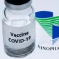 Botol bertuliskan "Vaksin COVID-19" terlihat di sebelah logo Sinopharm, 23 November 2020. Pemerintah Uni Emirat Arab (UEA) telah menjamin vaksin COVID-19 buatan Sinopharm halal. (JOEL SAGET/AFP)