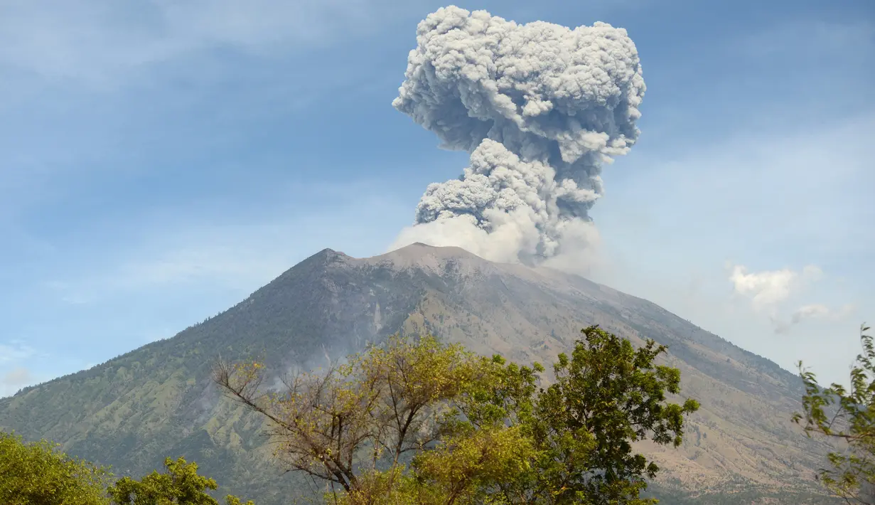 Asap bercampur abu vulkanis keluar dari kawah Gunung Agung terlihat dari desa Tulamben, Karangasem, Bali, Selasa (3/7). Pagi ini, Gunung Agung kembali meletus disertai abu vulkanik setinggi 2.000 meter di atas puncak. (AFP/SONNY TUMBELAKA)