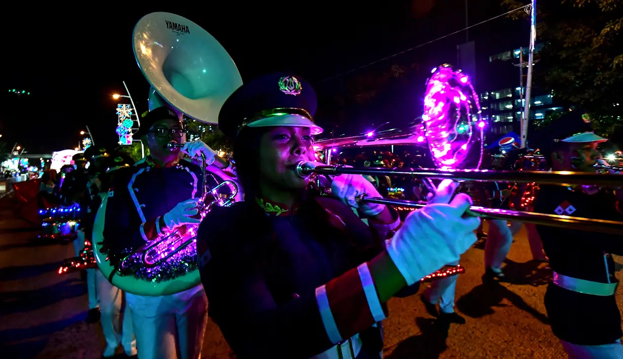 Seorang wanita memainkan terompet selama parade Natal di Panama City (16/12). Warga Panama tengah mempersiapkan diri menyambut datangnya Natal 2018 yang jatuh pada tanggal 25 Desember. (AFP Photo/Luis Acosta)