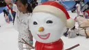 Seorang anak berpose disamping boneka es di Snow Village di salah satu pusat perbelanjaan di kawasan Tangsel, Senin (17/12). Jelang Natal dan Tahun Baru sejumlah pusat perbelanjaan menyajikan kegiatan untuk menarik pengunjung. (Merdeka.com/Arie Basuki)