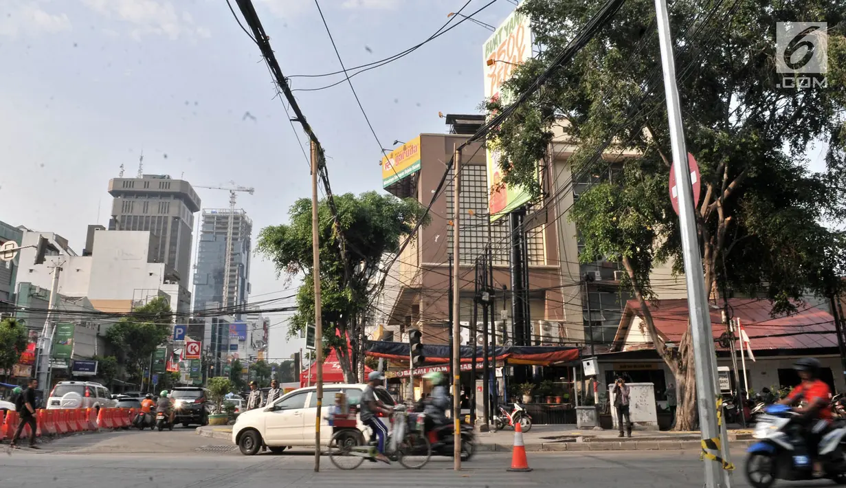 Kendaraan saat melintasi bambu penyangga kabel di Jalan Wahid Hasyim, Jakarta, Selasa (6/11). Dua buah bambu penyangga kabel tersebut mengganggu kenyamanan dan mengancam keselamatan pengguna jalan. (Merdeka.com/Iqbal S. Nugroho)