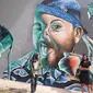 Dua seniman mural Indonesia Bunga dan Kare berpose di depan karya mereka di Singapura.