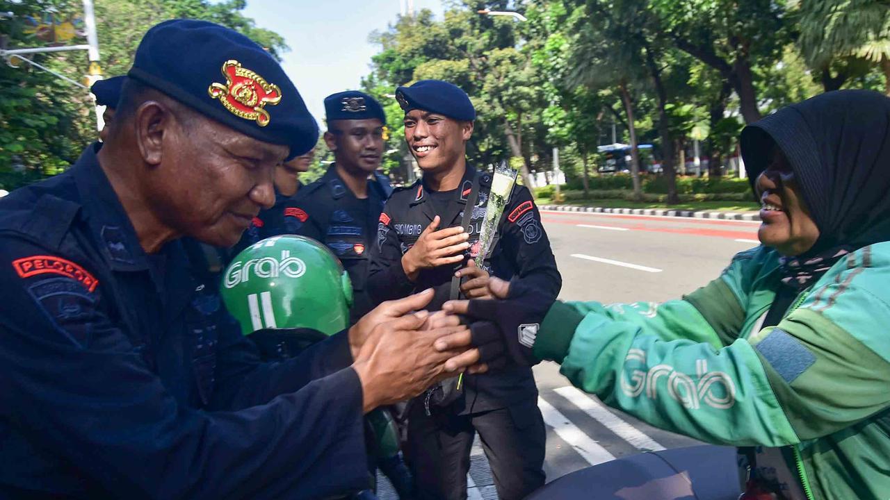 FOTO: Aksi Damai Ojol Tebar Mawar untuk Perdamaian Jakarta