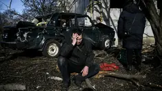 Seorang pria duduk di luar gedungnya yang hancur setelah pemboman di Kota Chuguiv, Ukraina timur, 24 Februari 2022. Angkatan bersenjata Rusia mencoba menyerang Ukraina dari beberapa arah, menggunakan sistem roket dan helikopter untuk menyerang posisi Ukraina di selatan. (Aris Messinis/AFP)