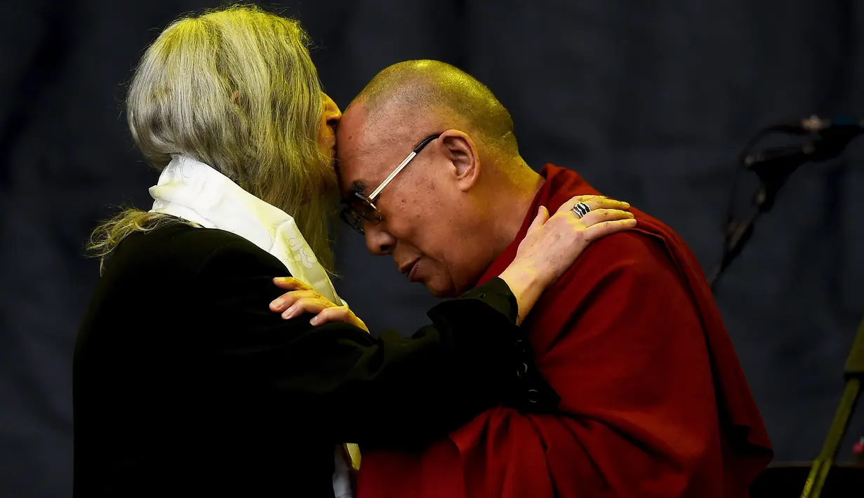 Musisi, Patti Smith mencium kepala Dalai Lama saat acara Glastonbury Festival, Inggirs, (28/6/2015). Dalai Lama akan berulang tahun yang ke-80 pada 6 Juli 2015 nanti. Namun ia merayakannya lebih awal di Glastonbury Festival. (REUTERS/Dylan Martinez)