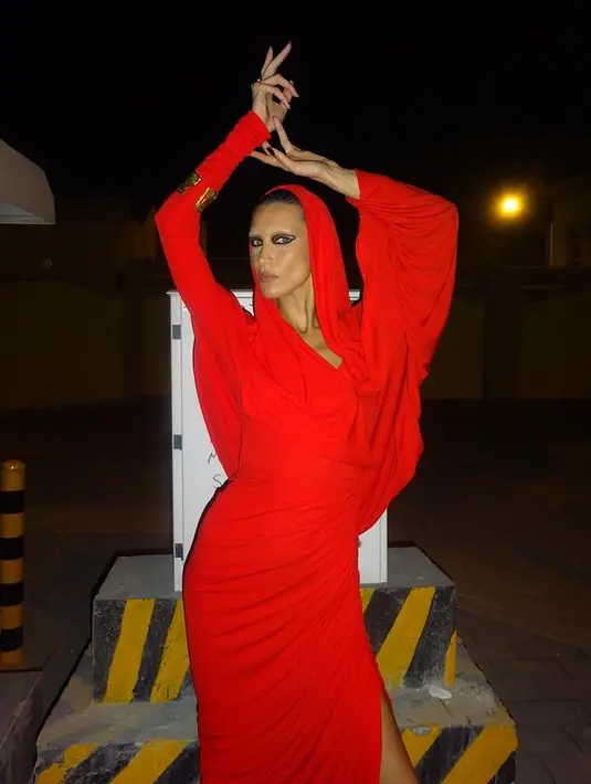 Bella Hadid pun merayakan Halloween di Qatar dengan gaun bernuansa merah. Gaun ini masih rancangan Schiaparelli dengan detail potongan tinggi dan kerudung. [instagram/bellahadid]