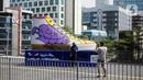 Warga berfoto di depan Tugu Sepatu, Sudirman, Jakarta, Minggu (19/9/2021). Tugu Sepatu menjadi sasaran pencoretan dengan semprotan aerosol oleh orang tak dikenal sehari usai diresmikan pada 17 September 2021. (Liputan6.com/Faizal Fanani)
