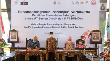 Dirut PT Semen Gresik, Mukhamad Saifudin (kiri), Direktur BUMDes PT Indo Kadiwono Sukses, Uswatun Khasanah (kanan) menandatangani Perjanjian Kerjasama Pendirian Perusahaan Patungan antara PT Semen Gresik dengan 6 PT BUMDes di Rembang, Kamis (9/4/2020). (Liputan6.com/Pool/SIG)