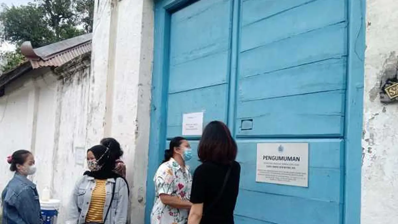 Beberapa abdi dalem Keraton Solo menunggu di pintu untuk mengantarkan makanan kepada lima orang yang terkunci di dalam Keraton Solo, Jumat (12/2/2021). (Foto: Solopos)