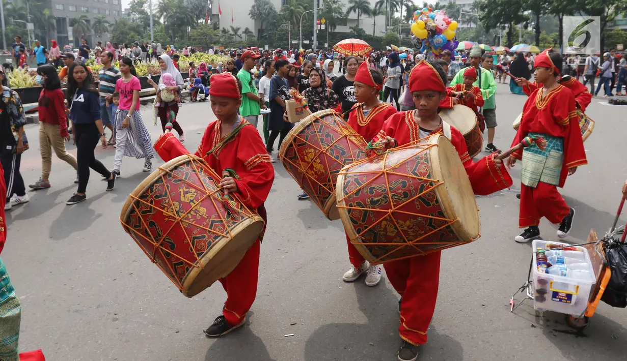 Seniman cilik memainkan alat musik tambur khas Minangkabau saat car free day (CFD) di Jakarta, Minggu (13/1). Pertunjukan ini juga sekaligus untuk mengenalkan keberagaman budaya Nusantara. (Liputan6.com/Angga Yuniar)