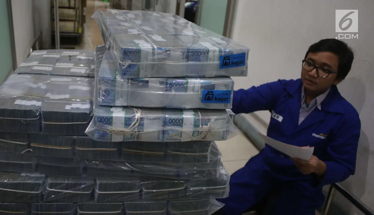 Petugas mengecek lembaran uang rupiah di Bank Mandiri, Jakarta, Kamis (21/12). Guna memenuhi kebutuhan uang tunai selama perayaan Natal dan Tahun Baru 2018, Bank Indonesia (BI) menyiapkan uang kartal sebanyak Rp 193,9 triliun. (Liputan6.com/Angga Yuniar)