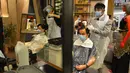 Para barber memangkas rambut pelanggan di sebuah tempat pangkas rambut di Kuala Lumpur, Juni 2020. Setelah hampir tiga bulan masa lockdown, pemerintah Malaysia melakukan pelonggaran sebagai upaya menghidupkan kembali perekonomian yang sempat terpukul akibat pandemi Covid-19. (Xinhua/Zhu Wei)