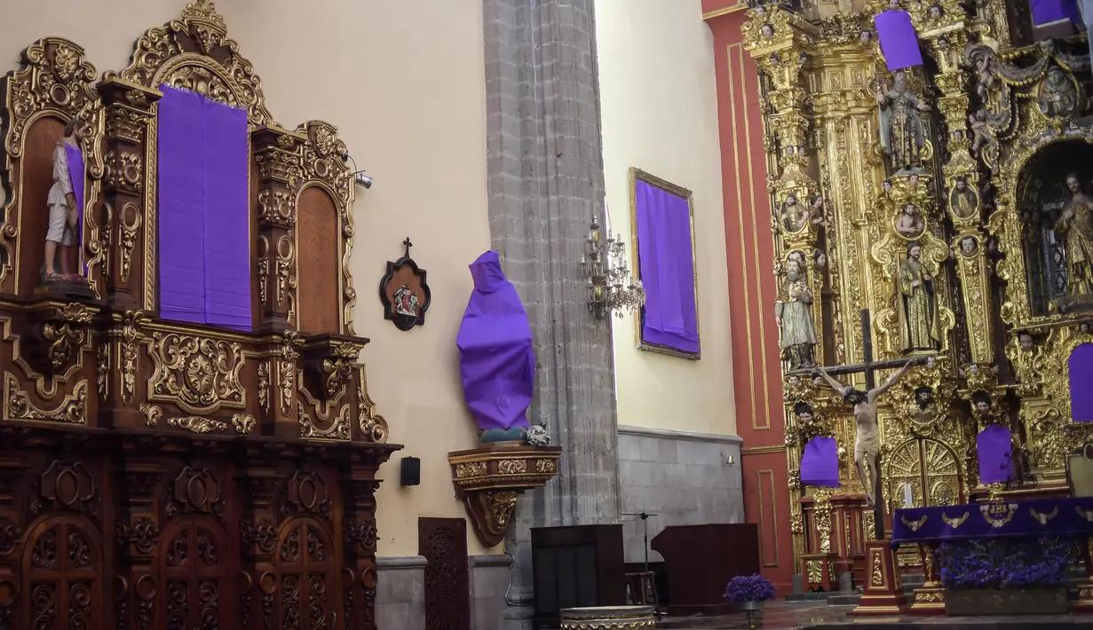 Pemandangan patung perempuan ditutupi dengan kain ungu di Gereja De los Santos Cosme y Damian di Mexico City, pada Rabu (4/3/2020). Penutupan patung tersebut sebagai bentuk protes terhadap kekerasan gender. (Photo by Pedro PARDO / AFP)