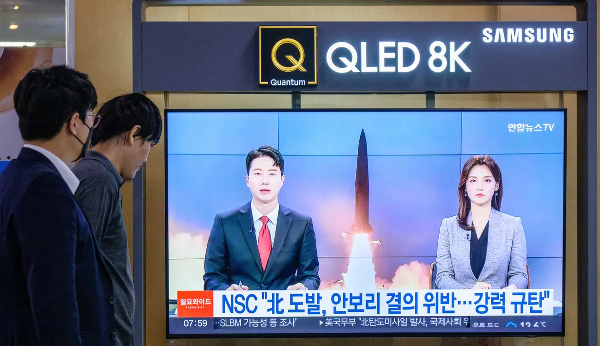 Orang-orang menonton siaran berita yang menunjukkan rekaman file uji coba rudal Korea Utara, di sebuah stasiun kereta api di Seoul, Korea Selatan, Minggu (9/10/2022).  Serangkaian uji coba itu telah memicu peringatan besar-besaran di Amerika Serikat (AS) dan Jepang. (Photo by ANTHONY WALLACE / AFP)
