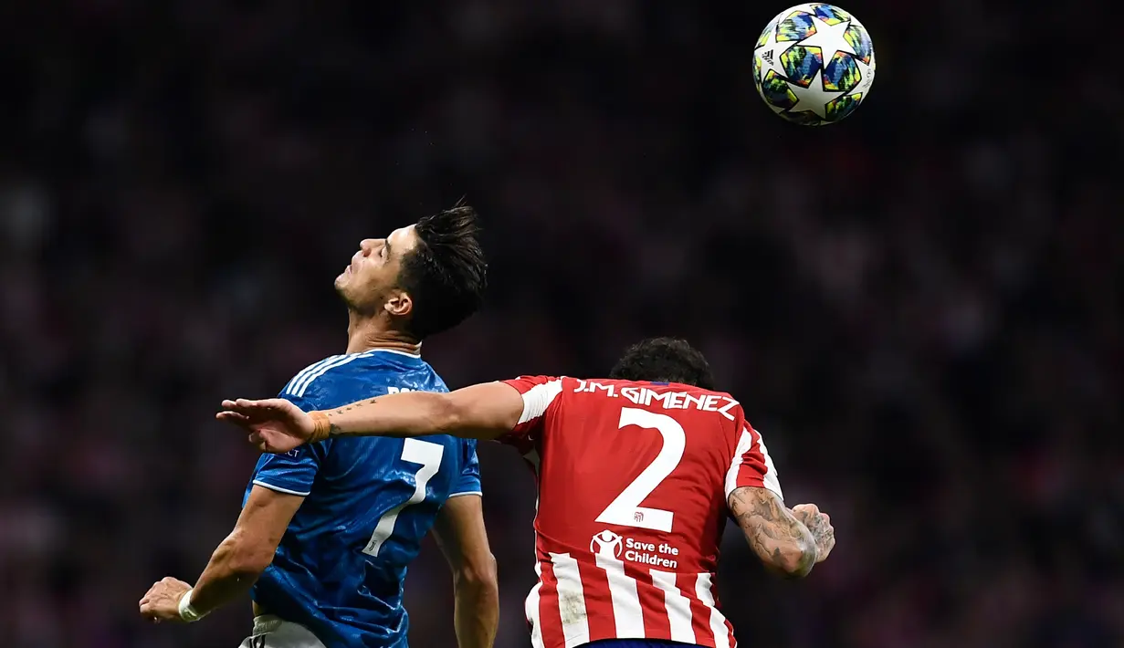 Megabintang Juventus, Cristiano Ronaldo melompat bersama bek Atletico Madrid Jose Gimenez saat berebut bola pada pertandingan matchday pertama Liga Champions Grup D di Estadio Wanda Metropolitano, Rabu (18/9/2019). Juventus dan Atletico Madrid harus puas berbagi angka 2-2. (OSCAR DEL POZO / AFP)