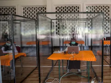 Peserta dengan hasil "rapid test" reaktif mengikuti ujian Seleksi Kompetensi Bidang (SKB) di bilik khusus di Surabaya, Selasa (22/9/2020). Badan Kepegawaian Daerah (BKD) Kota Surabaya menggelar ujian SKB yang diikuti 1.142 peserta CPNS dengan protokol COVID-19 secara ketat. (Juni Kriswanto/AFP)