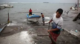 Para nelayan memindahkan perahu mereka dari Teluk Meksiko menuju pinggir jalan di pelabuhan kota Veracruz, Rabu (9/8). Meksiko bersiap untuk menghadapi kedatangan Franklin, yang berubah menjadi badai dengan Kategori 1. (AP/Felix Marquez)