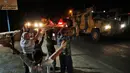 Warga menyaksikan konvoi militer Turki menuju kota Akcakale, dekat dengan perbatasan Suriah, di provinsi Sanliurfa, Selasa (8/10/2019). Turki mengirim banyak kendaraan lapis baja ke perbatasan dengan Suriah setelah menyatakan siap melakukan tindakan ofensif lintas perbatasan. (AP/Lefteris Pitarakis)