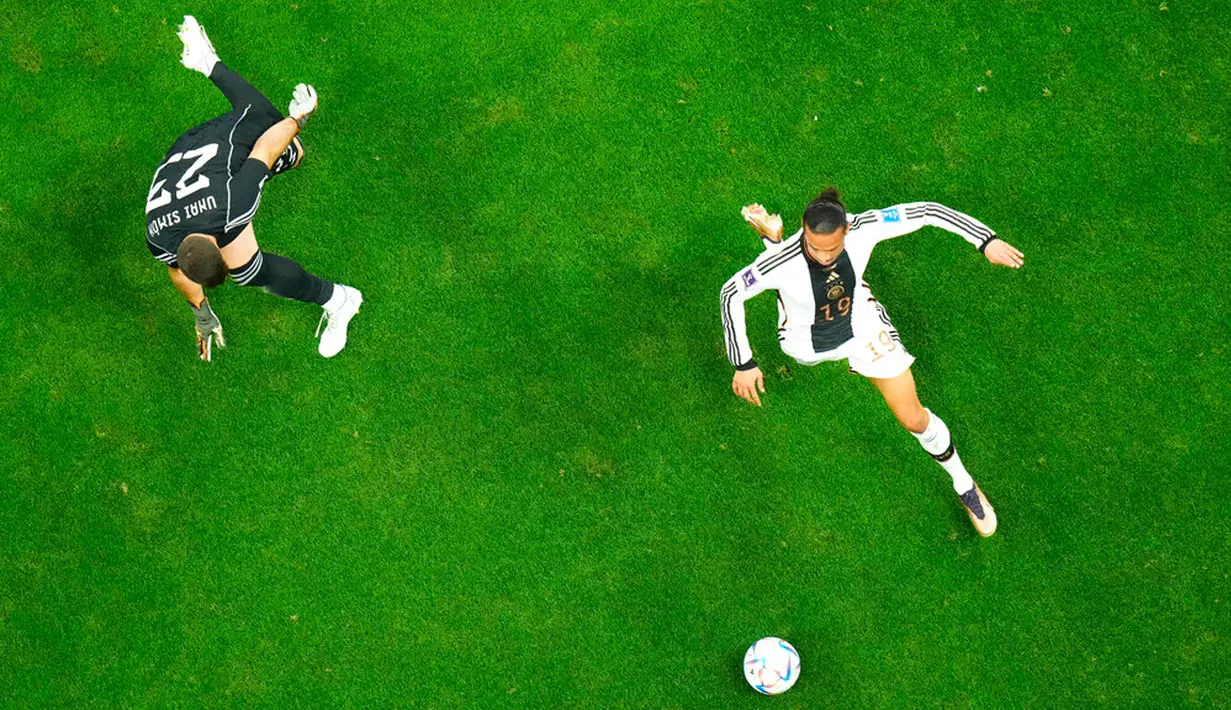 Pemain Jerman Leroy Sane membawa bola melewati kiper Spanyol Unai Simon pada pertandingan sepak bola Grup E Piala Dunia 2022 di Stadion Al Bayt, Al Khor, Qatar, 27 November 2022. Pertandingan berakhir imbang 1-1. (AP Photo/Petr David Josek)