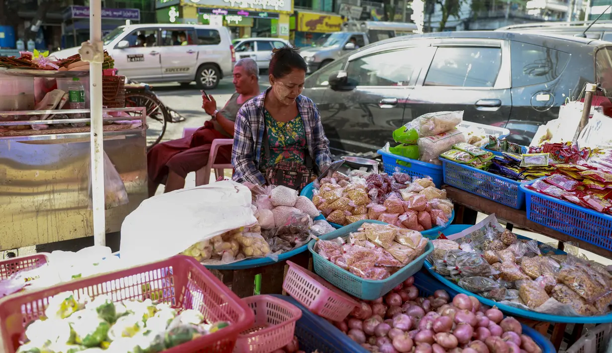 Seorang pedagang kaki lima memeriksa ponselnya di Yangon, Myanmar (4/2/2021).   Pemerintahan Militer Myanmar dikabarkan juga memerintahkan operator seluler untuk memblokir WhatsApp, dan Instagram hingga 7 Februari tengah malam. (AP Photo)