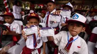 Sejumlah siswa memperlihatkan Kartu Indonesia Pintar (KIP) di Ambon, Maluku, (8/2). Jokowi membagikan sekitar 1.265 KIP untuk para siswa di Ambon. (Liputan6.com/Faizal Fanani)