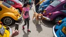 Seorang peserta membawa anjingnya saat mengikuti ajang pertemuan tahunan "Beetle club" di Yakum, Israel tengah (21/4). (AP Photo / Oded Balilty)