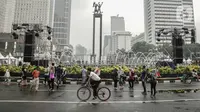 Warga beraktivitas saat car free day (CFD) di kawasan Bundaran HI, Jakarta, Minggu (29/12/2019). Kendati tidak seramai saat cerah, warga yang berlari, jalan santai, atau swafoto masih menjadi pemandangan di area CFD usai hujan mengguyur Jakarta. (Liputan6.com/Faizal Fanani)