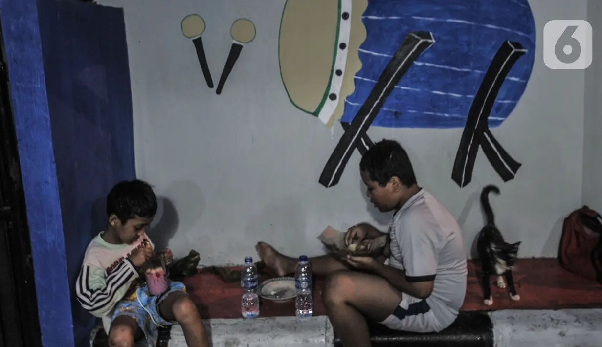 Anak-anak menikmati makanan di 'Kampung Ramadhan' di Jalan Martapura, Kelurahan Kebon Melati, Kecamatan Tanah Abang, Jakarta, Rabu (28/4/2021). Memeriahkan bulan Ramadan, warga menghias permukiman dan rumah mereka dengan mural dan hiasan bertema Ramadan. (merdeka.com/Iqbal S. Nugroho)