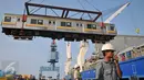 Pekerja memindahkan gerbong KRL dari kapal menggunakan alat berat di Pelabuhan Tanjung Priok, Jakarta, Rabu (6/1). Kedatangan gerbong KRL ini menandai akhir program pengadaan 120 kereta PT KAI Commuter Jabodetabek tahun 2015. (Liputan6.com/Gempur M Surya)