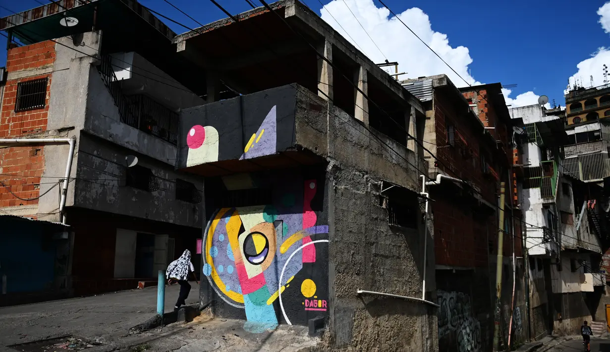 Warna-warni mural menghiasi tembok di permukiman kumuh Petare di Caracas pada 29 Mei 2019. Petare yang merupakan kawasan kumuh terbesar di Venezuela menjadi rumah bagi lebih dari 500.000 jiwa. (Photo by MARVIN RECINOS / AFP)