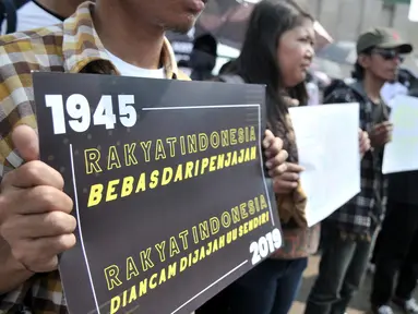 Massa yang tergabung dalam Koalisi Masyarakat Menyelamatkan KPK membentangkan poster saat aksi menolak UU KPK di Gedung DPR, Jakarta, Selasa (17/9/2019). Dalam aksinya massa membawa poster bertuliskan kekecewaan terhadap Jokowi dan DPR karena mengesahkan UU KPK. (merdeka.com/Iqbal S. Nugroho)