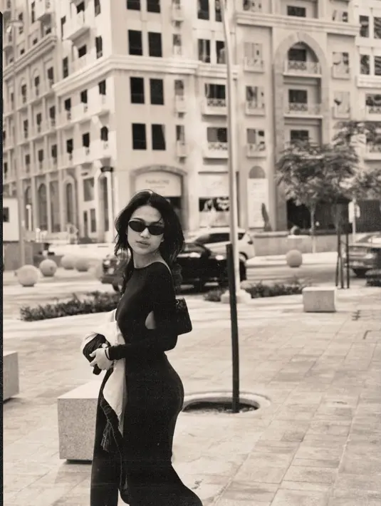 <p>Momen lain, Azizah memancarkan pesona bold misterius mengenakan slim fit backless dress warna hitam. Penampilannya makin kece dengan kacamata hitam. [@azizahsalsha_]</p>
