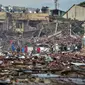 Orang-orang melihat rumah-rumah yang hancur akibat ledakan yang mengoyak gudang kembang api, di distrik Sungai Kolok di provinsi Narathiwat, Thailand selatan, pada 29 Juli 2023. (Madare TOHLALA / AFP)