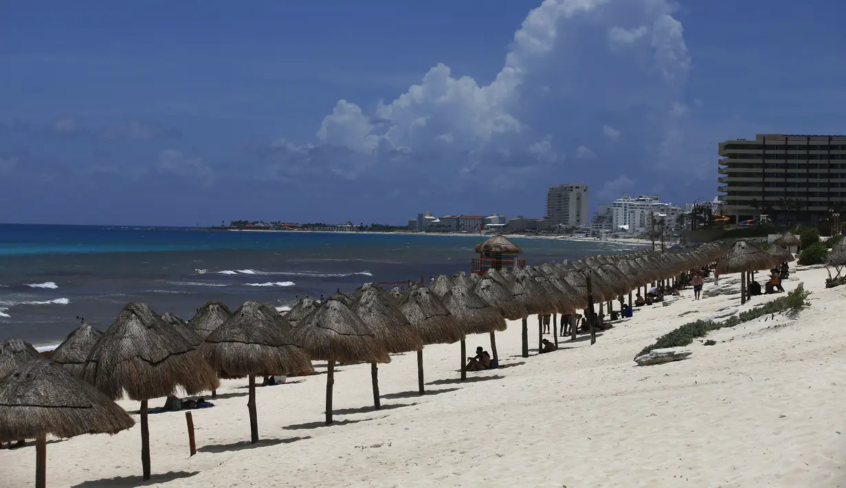 Wisatawan menikmati pantai sebelum kedatangan Badai Grace, di Cancun, Meksiko, Rabu (18/8/2021). Badai tropis Grace yang menguat menjadi badai pada 18 Agustus 2021 meluncur ke arah pantai Karibia, Meksiko dan mengancam akan membawa hujan lebat, banjir bandang dan gelombang besar. (AP/Marco Ugarte)