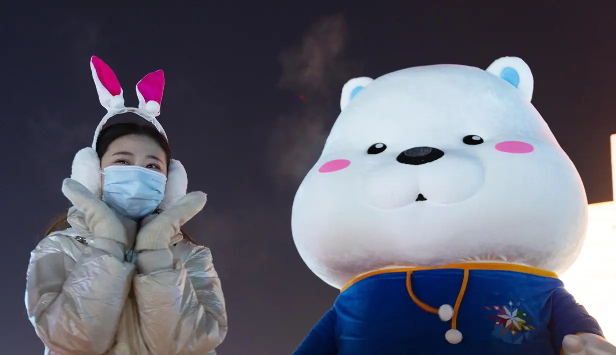 Seorang wanita memberi isyarat di Harbin Ice-Snow World di Harbin di Provinsi Heilongjiang, China timur laut, Sabtu (25/12/2021). Dunia Es-Salju Harbin ke-23 dibuka untuk umum pada hari Sabtu. (Wang Jianwei/Xinhua via AP)