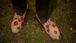 Seorang desainer pameran taman mengenakan sepatu dengan gambar kepik selama RHS Chelsea Flower Show 2021 di London pada Senin (20/9/2021). Pertunjukan bunga Chelsea sempat ditunda dari tanggal musim semi biasanya karena pembatasan penguncian di tengah pandemi COVID-19. (AP Photo/Matt Dunham)