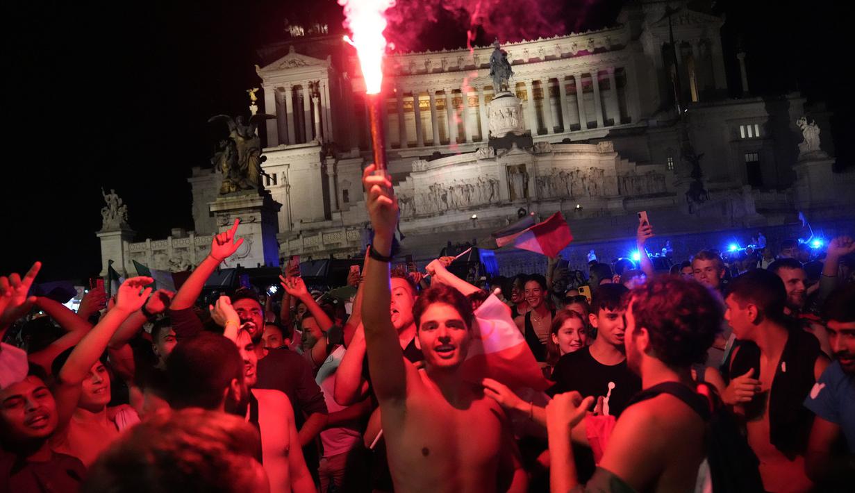 Pendukung Italia merayakan kemenangan di Roma, Italia pada Senin (12/07/2021), setelah Italia berhasil mengalahkan Inggris pada Final Euro 2020 yang berlangsung di Stadion Wembley, London, Inggris. Italia mengalahkan Inggris 3-2 dalam adu penalti setelah bermain imbang 1-1. (AP/Alessandra Tarantino)
