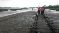 Petugas Daops 3 Cirebon tengah memeriksa kerusakan akibat banjir yang merendam jalur kereta api di perlintasan Brebes Jawa Tengah. (Istimewa / Panji Prayitno)