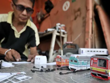 Iskandar (52) saat menyelesaikan pembuatan miniatur kereta api di kawasan Manggarai, Jakarta, Kamis (21/11/2019). Sudah 6 tahun bapak dari 2 anak ini menekuni profesi sebagai pembuat miniatur kereta api berbagai jenis, mulai dari KRL, kereta jarak jauh, hingga MRT. (merdeka.com/Iqbal S. Nugroho)