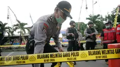 Petugas memasang garis polisi di lokasi bom bunuh diri di Mapolresta Solo, Jawa Tengah, Selasa (5/7). Garis polisi tersebut dipasang mulai dari sisi barat jalan Adi Sucipto menuju sisi timur Jalan KS Tubun. (Liputan6.com/Boy Harjanto)